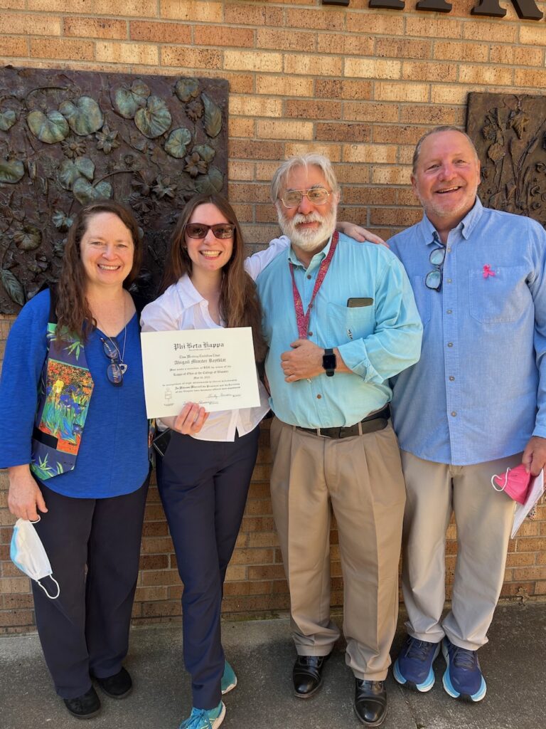 a 2025 PBK Inductee and family smile at the camera in Scheide Music Center
