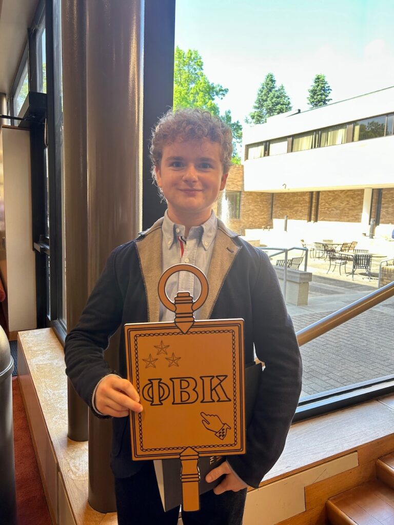 a 2025 Inductee holding the PBK key smiles at the camera in Scheide Music Center