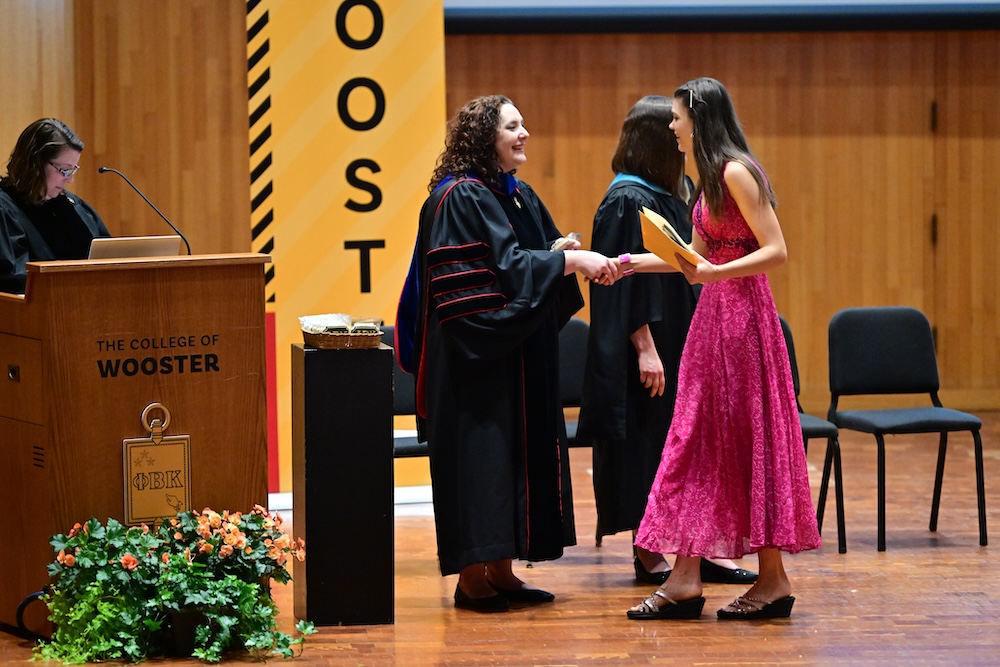 a 2025 PBK inductee gives the secret handshake to a staff member in Gault Recital Hall