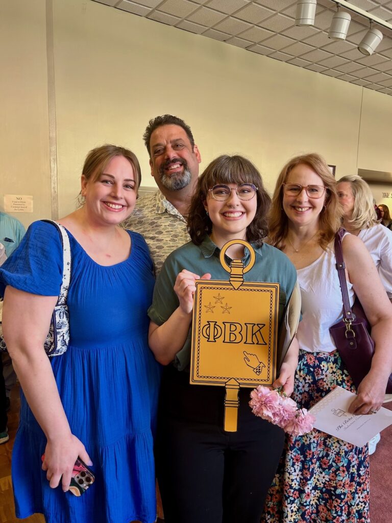 a 2025 PBK Inductee and family smile at the camera in Scheide Music Center