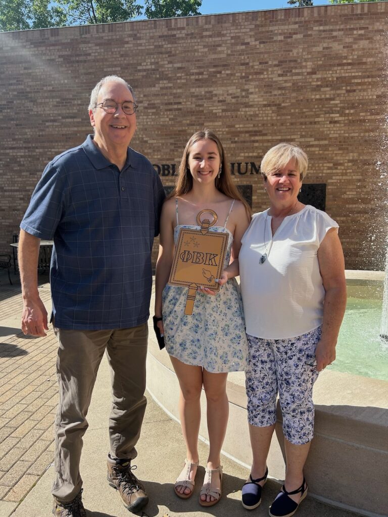 a 2025 PBK Inductee and family smile at the camera in Scheide Music Center