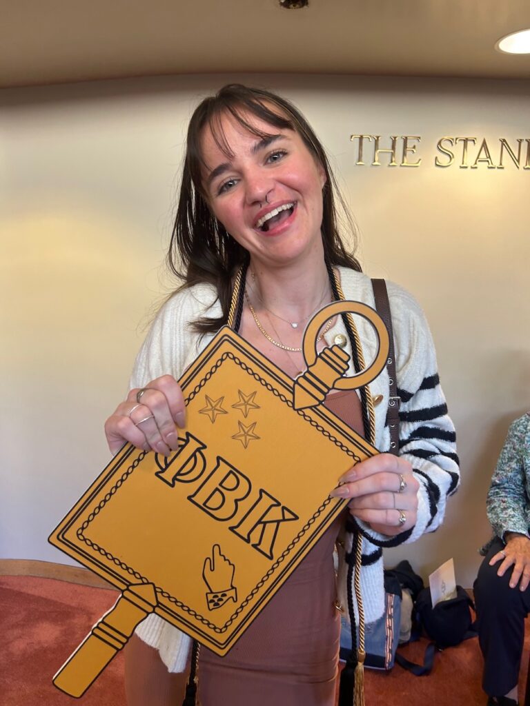 a 2025 Inductee holding the PBK key smiles at the camera in Scheide Music Center