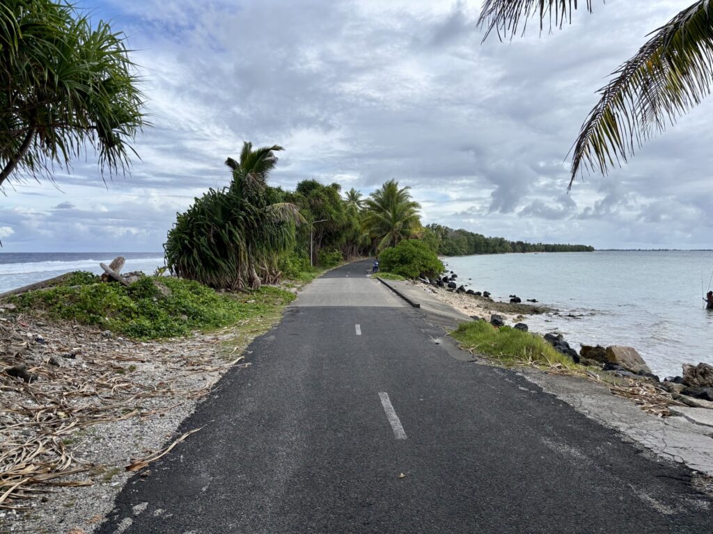 Photo of narrow road in Tuvalu with the ocean on one side and the lagoon on the other.