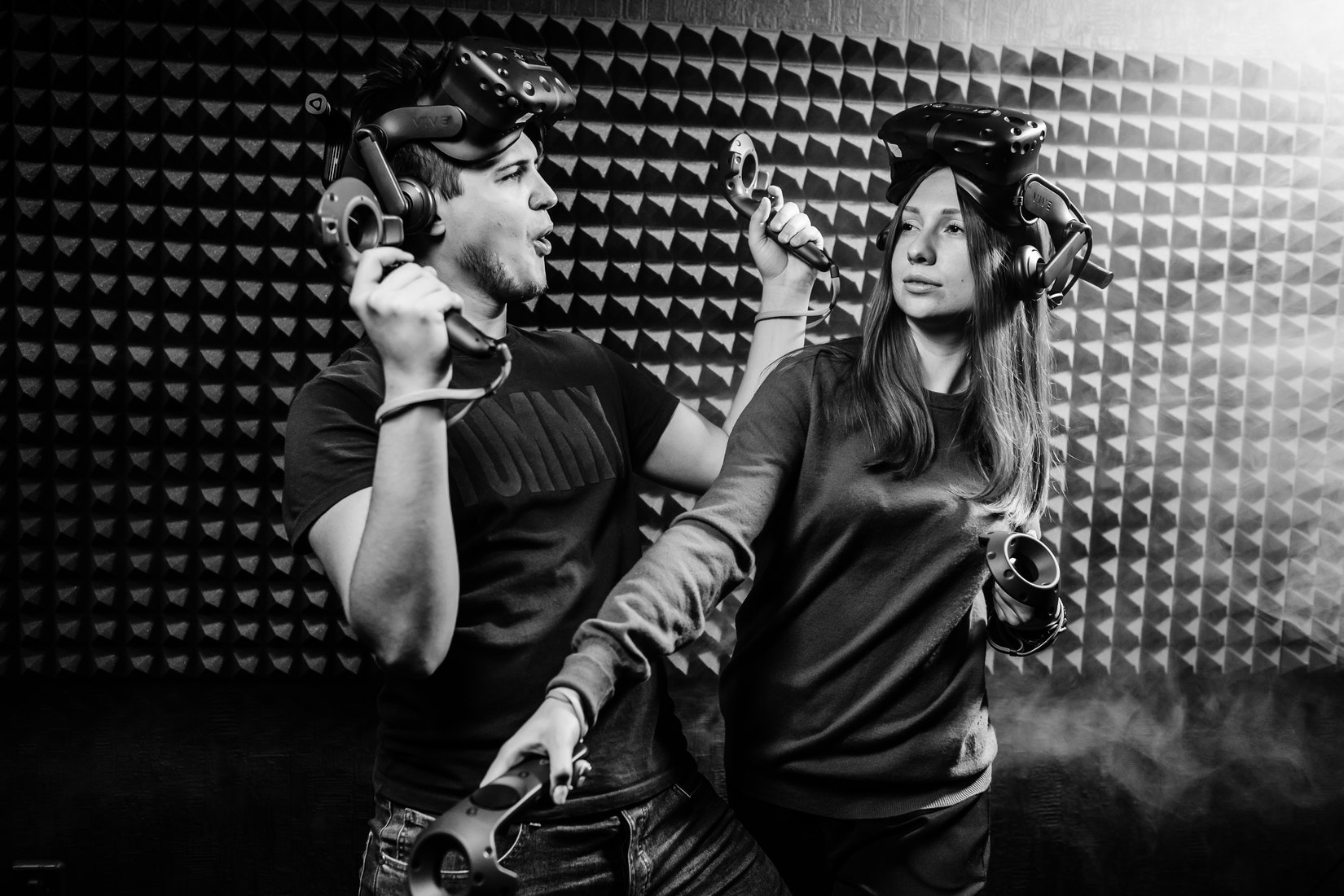Black and white photo of two people playing with virtual reality headset