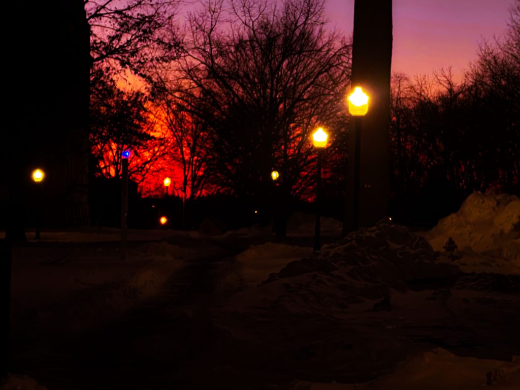 Vibrant and beautiful darkened picture of snowy sunset with exaggerated oranges and purples.
